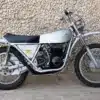 1972 Yankee Z500 Enduro Motorrad in silberner Lackierung seitlich vor einer Steinmauer.