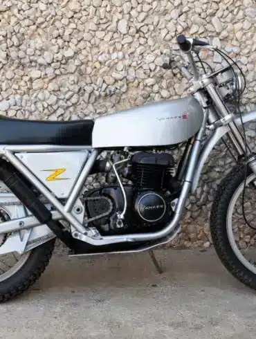 1972 Yankee Z500 Enduro Motorrad in silberner Lackierung seitlich vor einer Steinmauer.