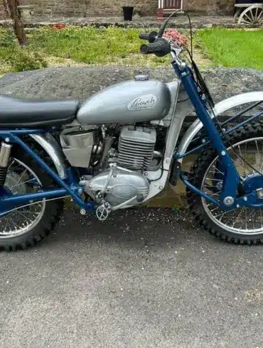 Seitenansicht einer blauen Greeves Hawkstone MCS 250cc von 1960, klassisches britisches Offroad-Motorrad mit periodentypischen Details.