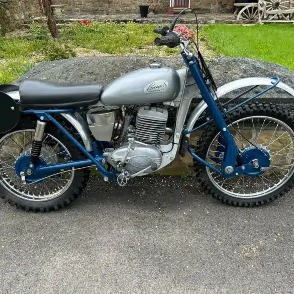Seitenansicht einer blauen Greeves Hawkstone MCS 250cc von 1960, klassisches britisches Offroad-Motorrad mit periodentypischen Details.
