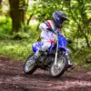 Jugendlicher auf einer Yamaha TT-R110 fährt Offroad durch einen Wald
