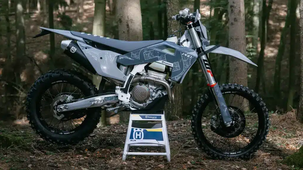 Seitenansicht der Husqvarna FE 350 Pro 2026 mit grauer Verkleidung im Wald.