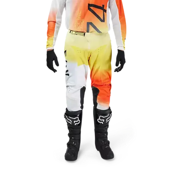 Motocrosshose Fox 180 Air Haze in Weiß-Gelb-Orange am Fahrer getragen, mit Knieeinsätzen aus Leder und Protektoren.