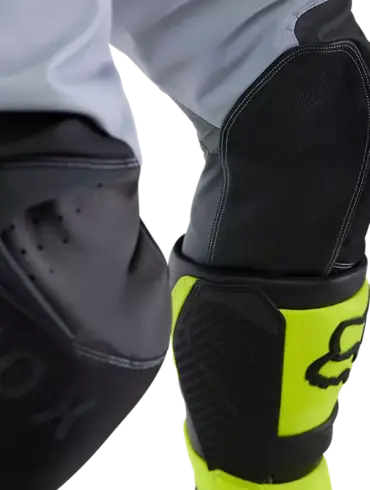 Kniebereich einer Motocross-Hose von Fox mit Lederbesatz und verstärkten Nähten, gelbe Stiefel im Bild
