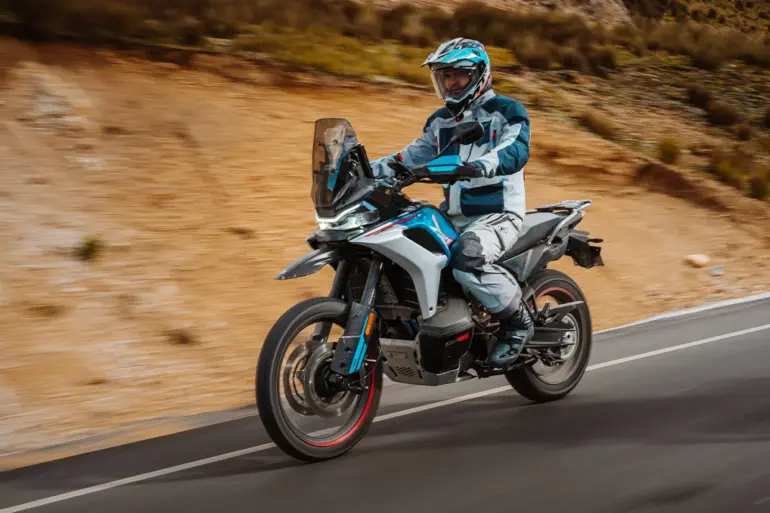 Adventure-Motorrad CFMoto 800MT-X auf Asphaltstraße mit Fahrer in voller Schutzkleidung