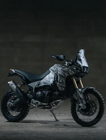 Seitenansicht einer Ducati DesertX V2 Reise-Enduro im Studio mit fokussiertem Offroad-Design und grobstolligen Reifen.