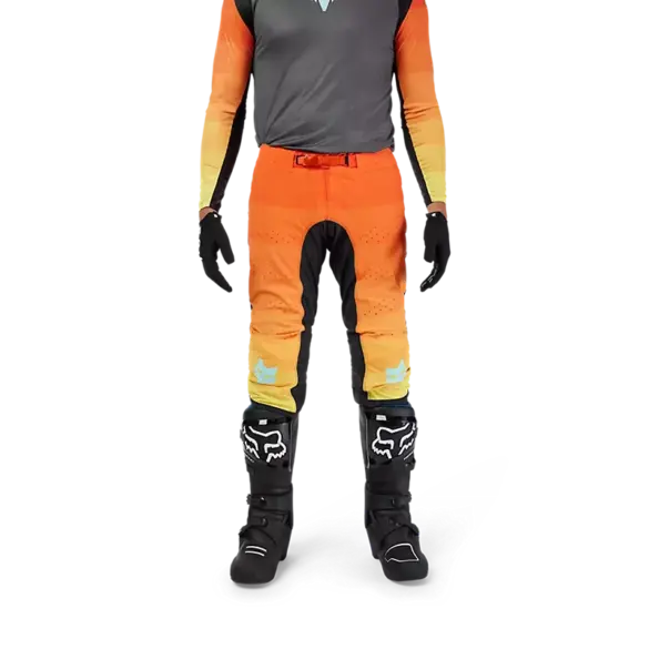 Flexair Grid Hose in Schwarz/Orange, getragen von einer Person mit Motocross-Stiefeln und Handschuhen, Vorderansicht.