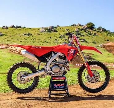 Honda CRF250R 2025 als Motocross-Motorrad vor einer Offroad-Strecke im Grünen