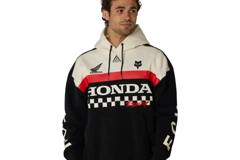 Modell trägt einen Honda Heavyweight Pullover Hoodie in Schwarz mit weißen und roten Akzenten, Honda- und Fox-Logos auf der Brust, klassischen Motorsport-Grafiken und Kapuze.