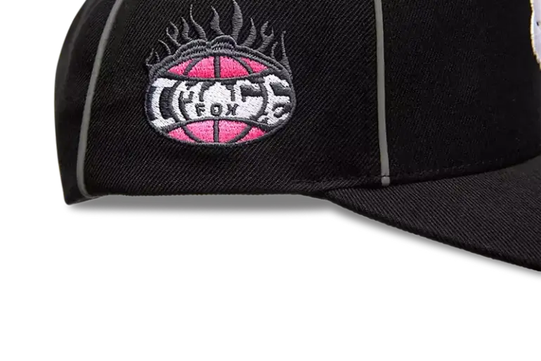 Nahaufnahme einer schwarzen Snapback Mütze mit reflektierender Paspel und gesticktem Logo