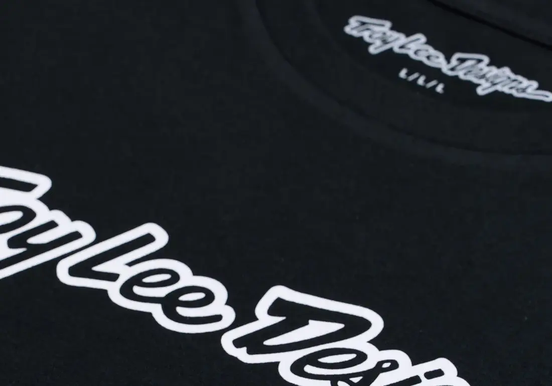 Nahaufnahme vom Troy Lee Designs Kurzarm-T-Shirt Signature Black mit weißem Logo-Schriftzug.