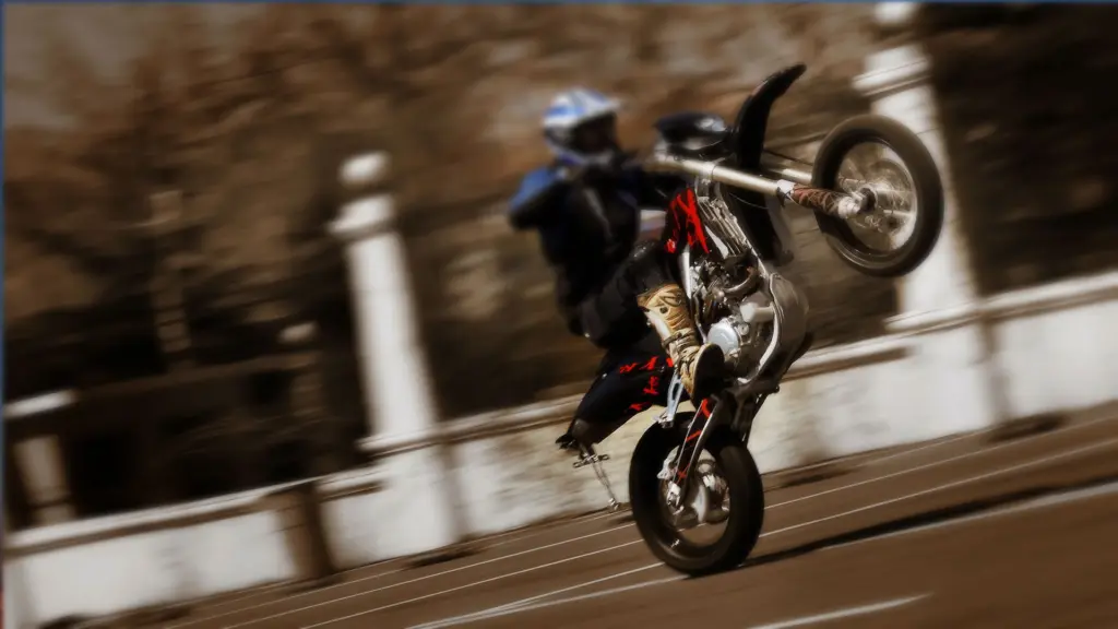 Motorradfahrer auf schwarzem Bike macht einen Wheelie auf Asphalt