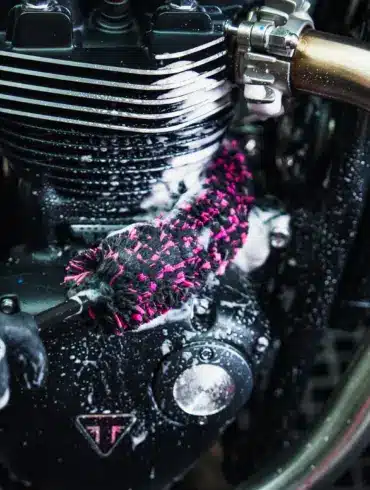Detailaufnahme: Mikrofaser-Bürste säubert einen Motorrad-Motor