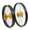 Motorrad Offroad-Radsatz mit schwarzen Felgen, Edelstahl-Speichen und goldenen Naben von Rex Wheels.