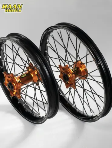 Zwei komplette Offroad-Laufräder mit schwarzen Felgen, CNC-gefrästen orange Aluminium-Naben und Edelstahlspeichen, geeignet für KTM SX-F und EXC Modelle