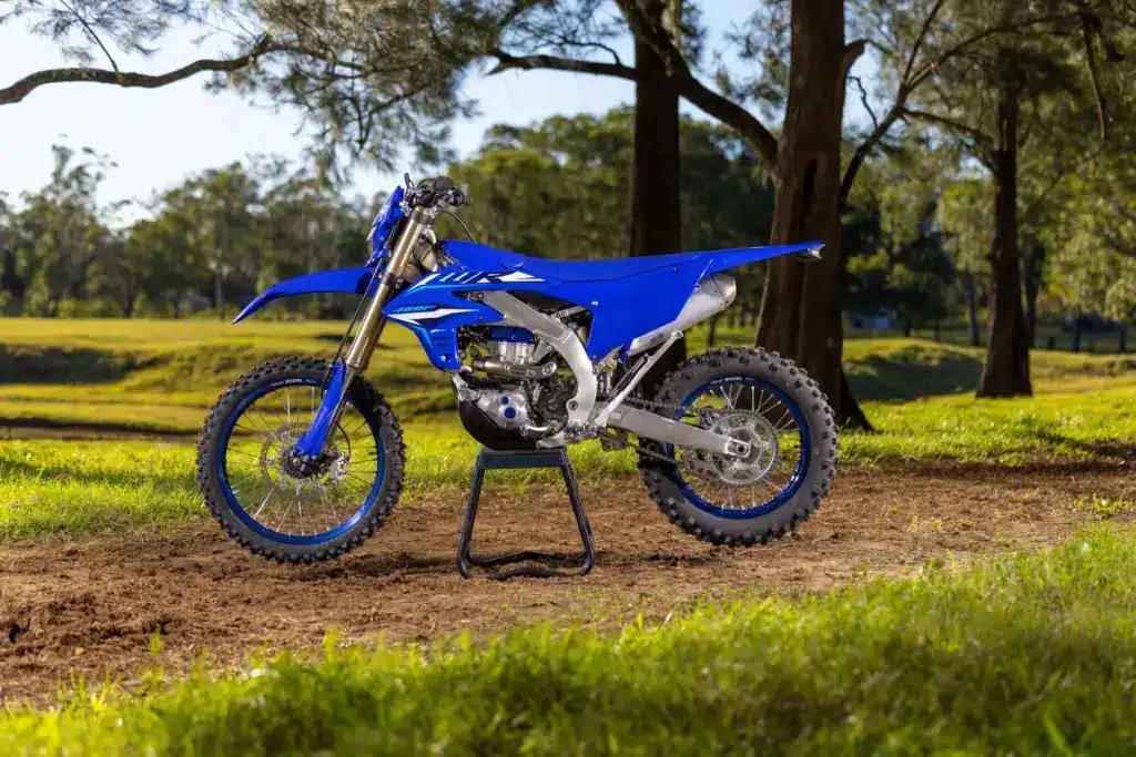 Yamaha WR450F 2026 in Icon Blue, seitlich auf Ständer im Gelände stehend.