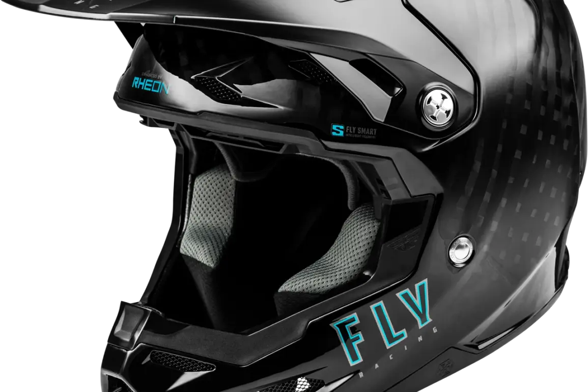 Seitliche Nahaufnahme eines schwarzen Fly Racing Helms mit Carbon-Struktur, Visier und großem Belüftungssystem.