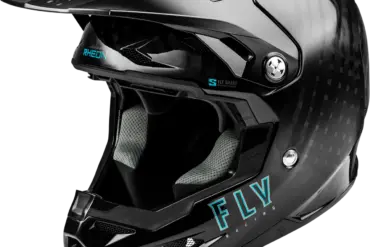 Seitliche Nahaufnahme eines schwarzen Fly Racing Helms mit Carbon-Struktur, Visier und großem Belüftungssystem.