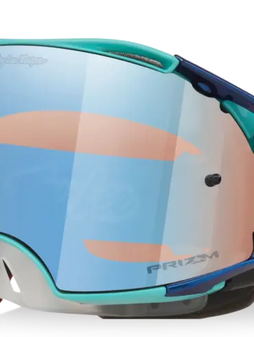 Oakley Airbrake MX Troy Lee Designs White Blue Stars mit reflektierendem Prizm MX Low Light Glas und verstellbarem, rot-blau gemustertem Band.