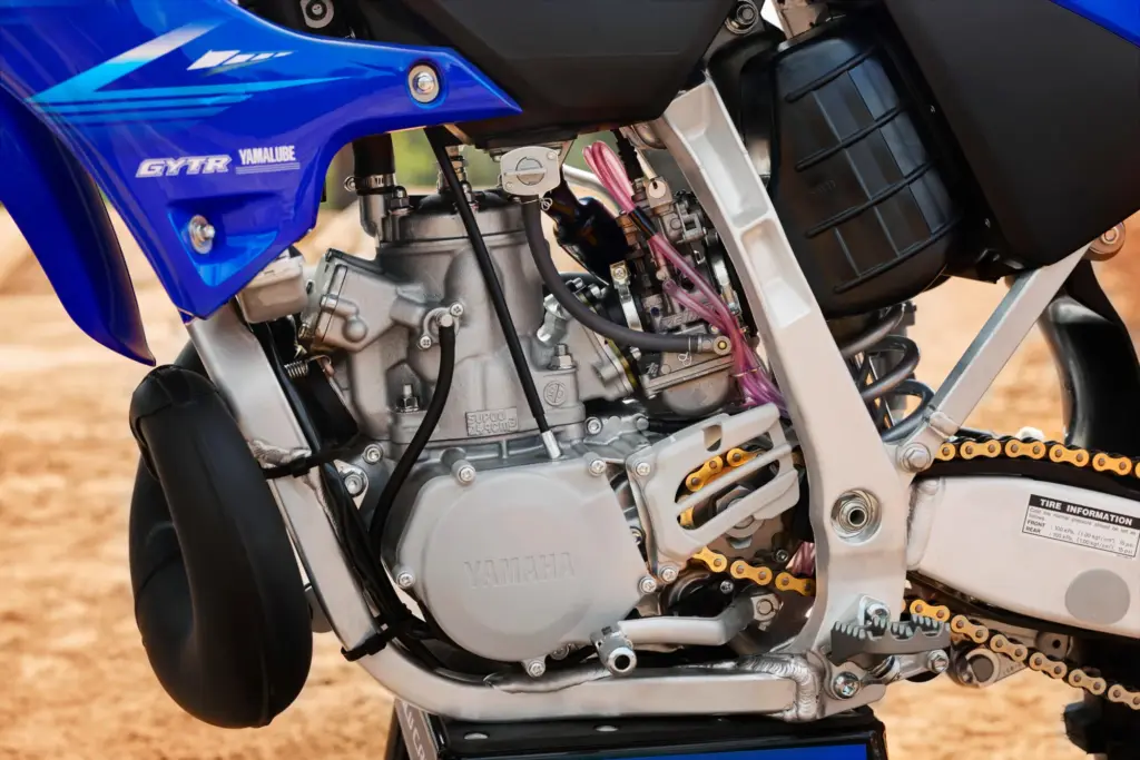Nahaufnahme des Motors einer Yamaha YZ250 Motocross-Maschine, seitliche Ansicht mit sichtbarem Auspuff und Antriebskette