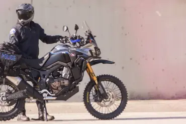 Honda Africa Twin Polizeimotorrad Redondo PD mit kompletter Einsatz-Ausrüstung, seitlich im Profil, Polizist in voller Montur.