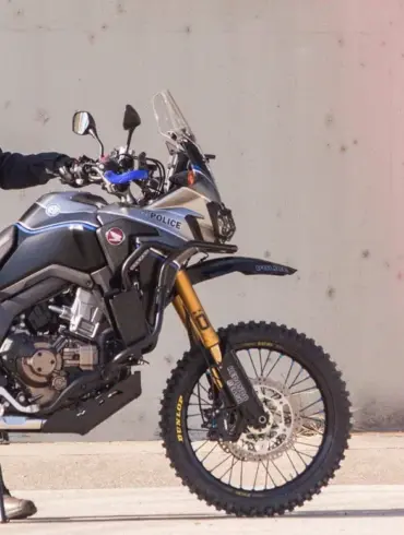 Honda Africa Twin Polizeimotorrad Redondo PD mit kompletter Einsatz-Ausrüstung, seitlich im Profil, Polizist in voller Montur.