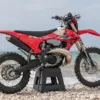 Rieju MR 300i RACING 2027 Sportenduro-Motorrad auf Steinen am Meer, Seitenansicht