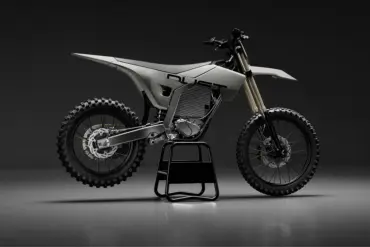 Elektrisches Dirtbike von Dust Moto auf einem Ständer vor dunklem Hintergrund.