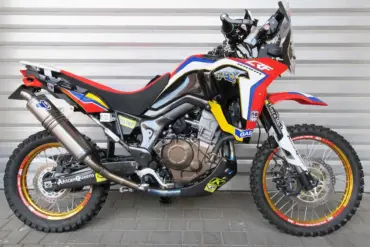 AQ Honda CRF 1000R Africa Twin Umbau mit Rallye-Kit, Öhlins-Federbein und Termignoni-Komplettanlage, Seitenansicht vor grauer Wand