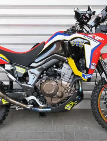AQ Honda CRF 1000R Africa Twin Umbau mit Rallye-Kit, Öhlins-Federbein und Termignoni-Komplettanlage, Seitenansicht vor grauer Wand