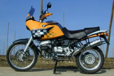 Seitenansicht einer umgebauten BMW R1100GS, genannt Bavarian Queen, mit auffälliger Verkleidung und Rallye-Ausstattung im Freien