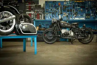BMW R50 Motorrad aus dem Jahr 1955 nach behutsamem Neuaufbau in einer Werkstatt vor blauer Werkzeugwand