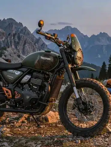 Triumph Scrambler 400 Escape Motorrad mit Campingausrüstung im Gebirge bei Abenddämmerung.
