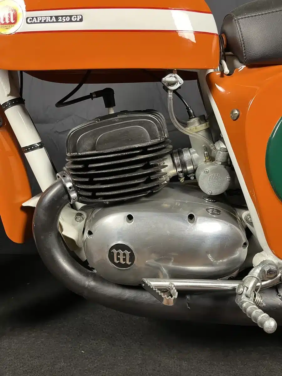 Nahaufnahme des Motors und Rahmens einer restaurierten orangen Montesa Cappra 250 GP von 1968