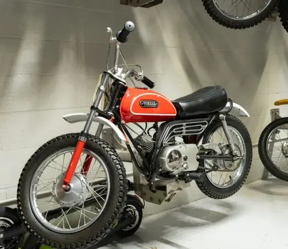 Rote 1970 Yamaha Mini Enduro MX ausgestellt im Innenraum, seitliche Ansicht