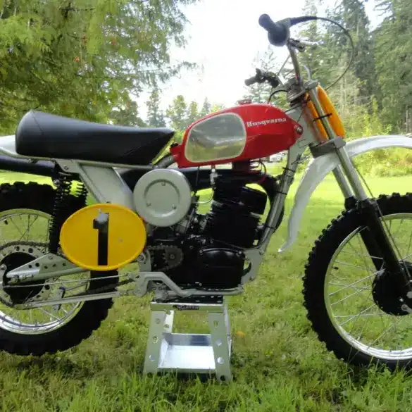 Motocross-Motorrad Husqvarna Pro-Fab Works 400CR Baujahr 1972, Seitenansicht im Freien, rote Tanklackierung, Startnummerntafel gelb mit schwarzer 1.