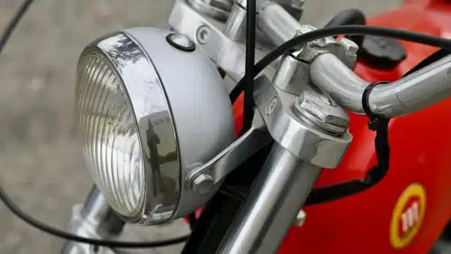 Scheinwerfer und Lenker einer roten Montesa Cota 1972 Enduro Trials im Detail