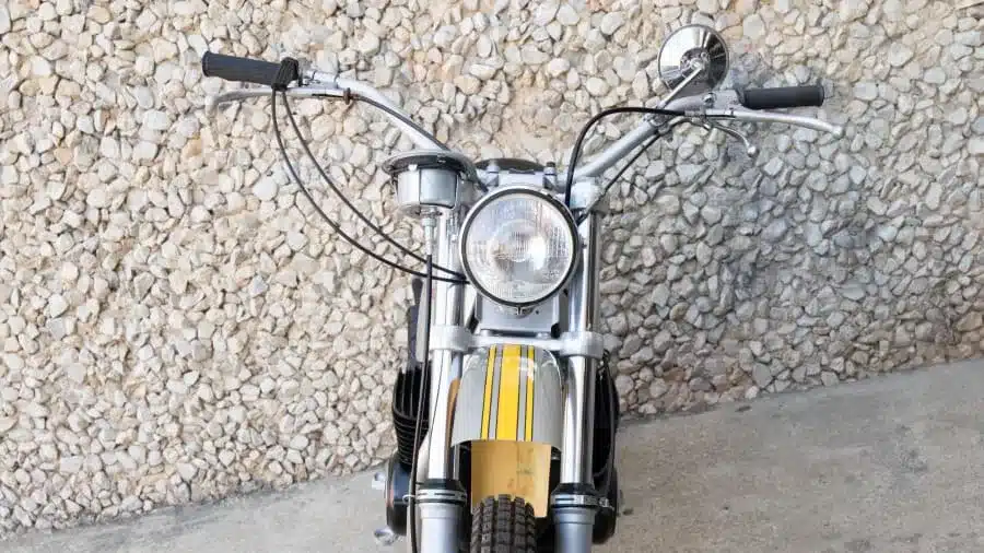 Frontansicht der 1972 Yankee Z500 Enduro, Motorradlenker und Scheinwerfer gut sichtbar vor einer Steinwand