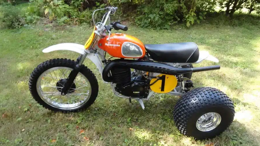 Seitenansicht des 1973 Husqvarna Super Cycle 450 CR 3-Wheelers mit charakteristischem Dreirad-Layout und orangefarbenem Tank