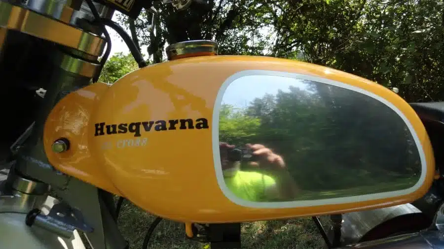 Nahaufnahme des Tanks einer 1974 Husqvarna 125CR Lightweight, gelb mit silbernem Einsatz und Husqvarna-Schriftzug.