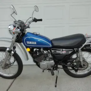 Seitenansicht einer blauen 1974 Yamaha DT175 Enduro mit verchromten Anbauteilen und Originalausstattung.