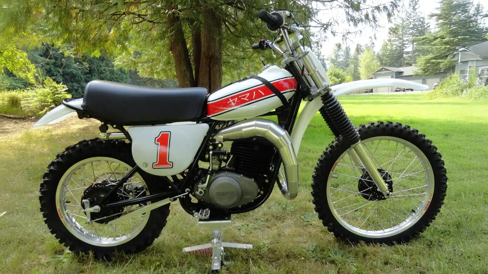Seitliche Ansicht einer 1976 Yamaha YZ250C mit Nummer 1 und typischen Motocross-Merkmalen.