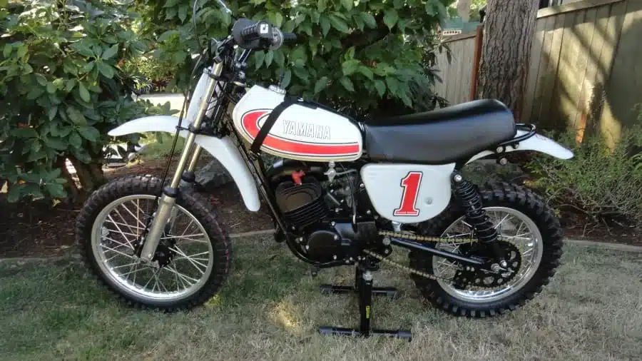 Seitenansicht einer 1977 Yamaha YZ80D, einem klassischen Motocross-Motorrad mit weißem Tank und der Startnummer 1.