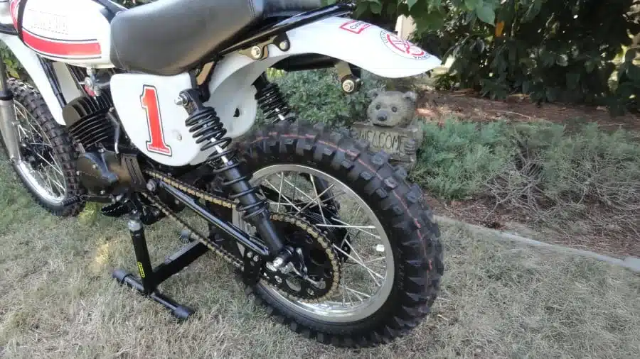 Yamaha YZ80D von 1977 mit Ständer, Startnummer 1 und grobstolligem Hinterreifen im Gras