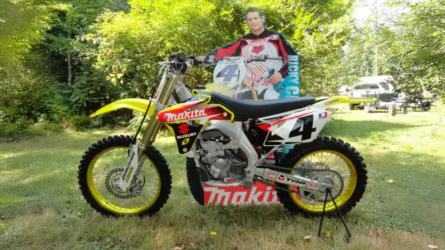 2007 Suzuki RM-Z450 Ricky Carmichael Special Edition mit Startnummer 4 im Freien aufgestellt, daneben eine Ricky Carmichael Figur.