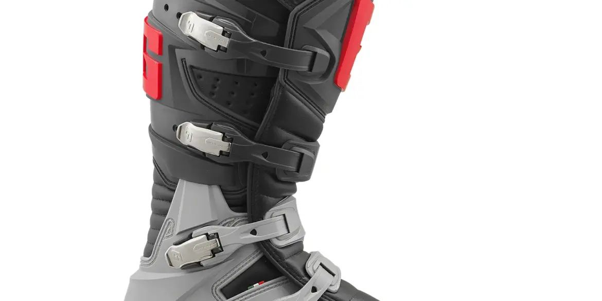 Seitenansicht des Gaerne GX1 Offroad-Stiefels mit grauen, schwarzen und roten Designelementen sowie vier Verschlussschnallen.