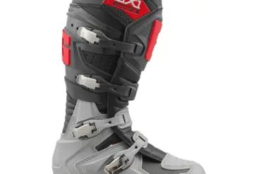Seitenansicht des Gaerne GX1 Offroad-Stiefels mit grauen, schwarzen und roten Designelementen sowie vier Verschlussschnallen.
