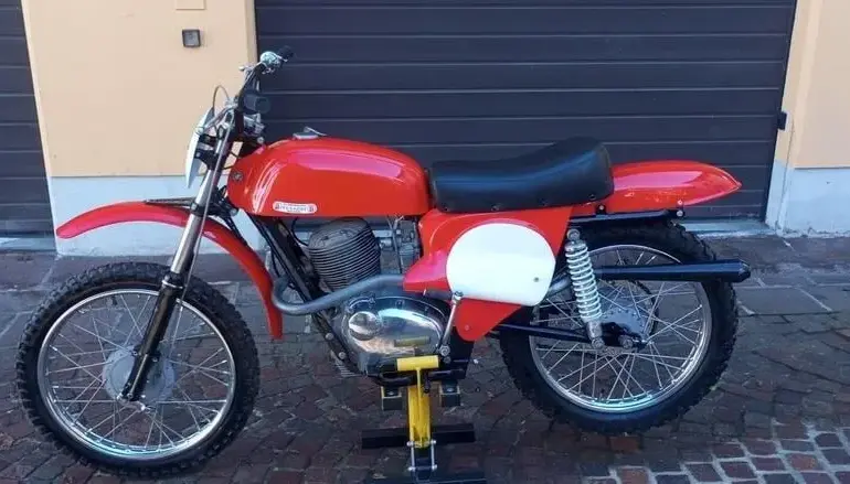 Restaurierte Gilera‑Bessone 175 Regolarità von 1970 in Rot, seitlich aufgestellt auf einem Montageständer vor Garagentor.