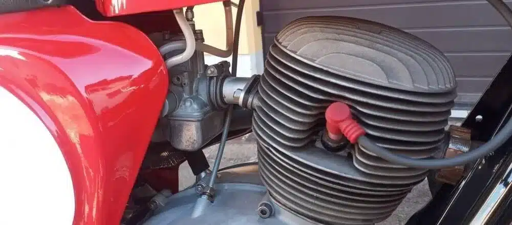 Detailfoto des Motors einer roten Gilera-Bessone 175, Baujahr 1970, mit sichtbarem Zylinderkopf und Vergaser