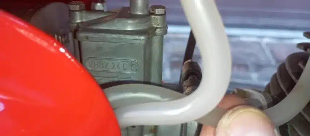 Detailansicht Vergaser mit Kraftstoffleitung an einer roten Gilera-Bessone 175, Baujahr 1970